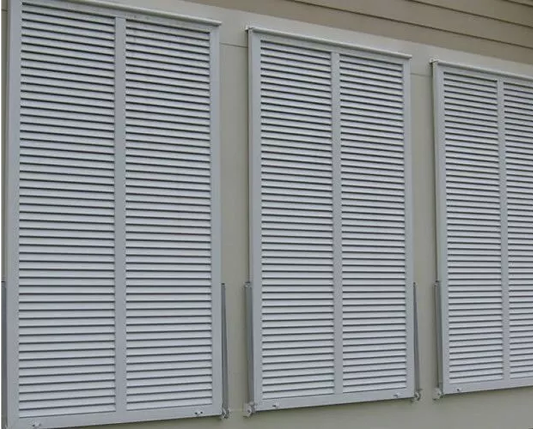 White hurricane shutters on a building exterior.