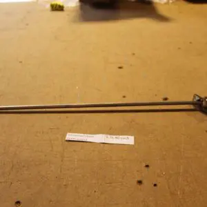 Metal rod with attached mechanism on table.