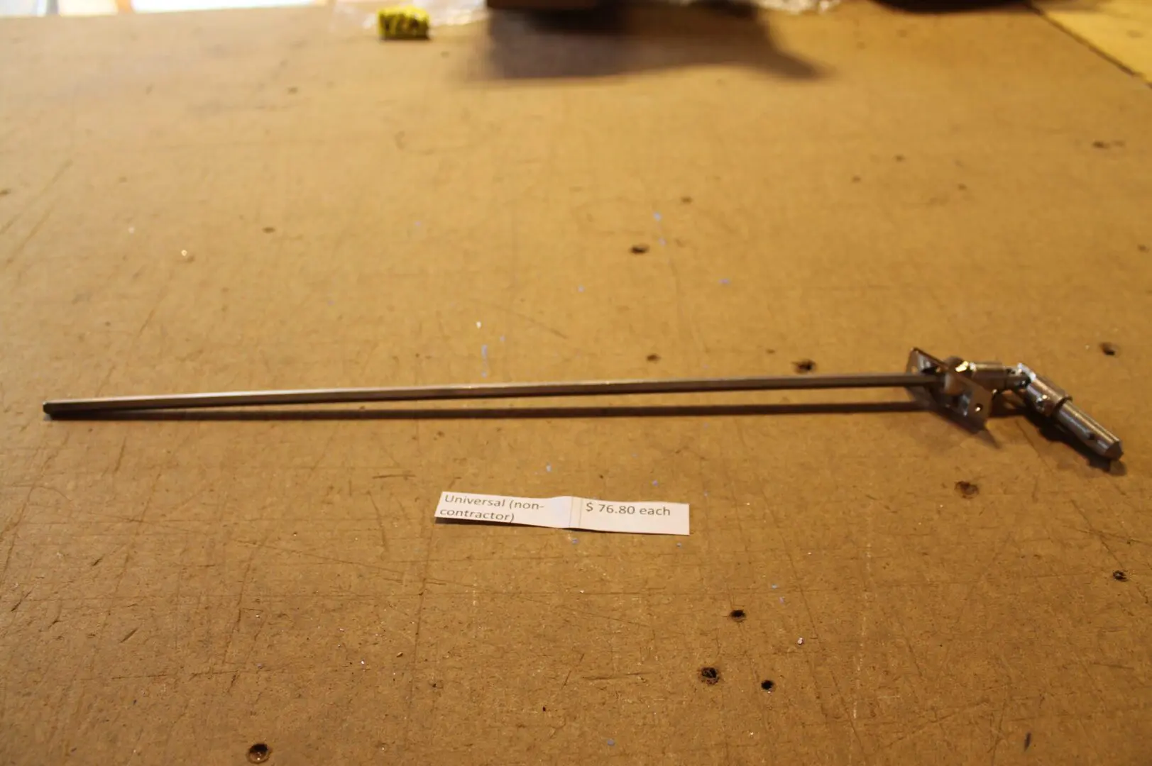 Metal rod with attached mechanism on table.