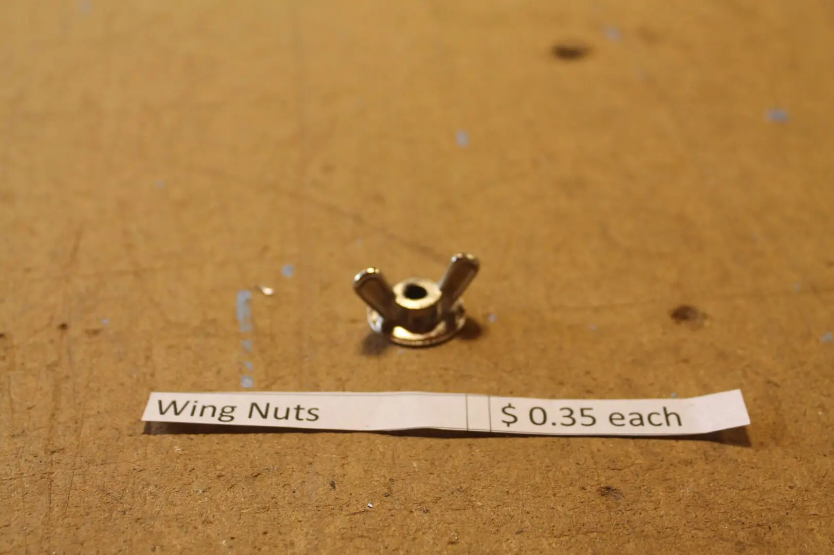 Wing nut with price tag on table.