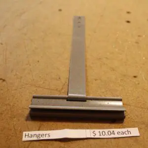 Metal hanger on wooden surface, $10.04.