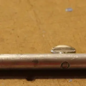 Metallic rod on a wooden surface.