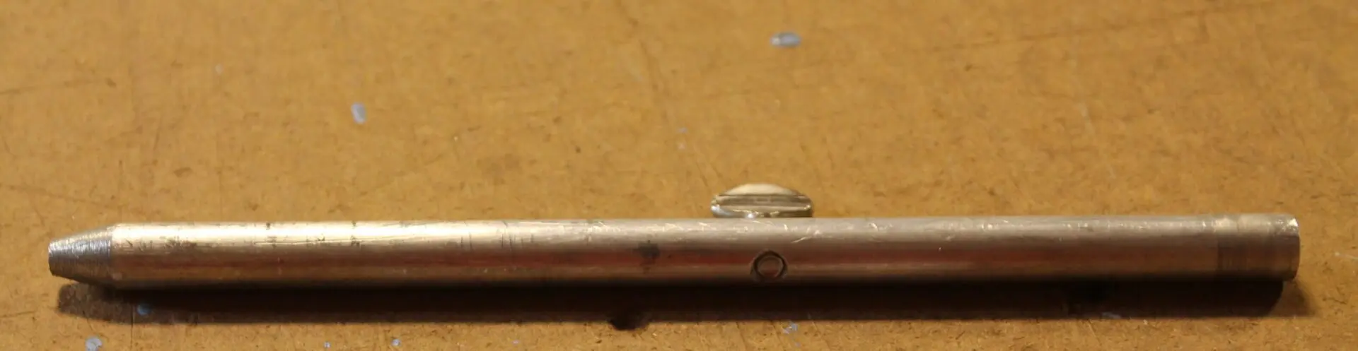 Metallic rod on a wooden surface.