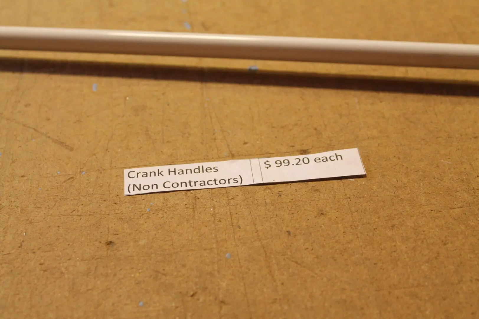 Crank handles price tag on wooden surface.