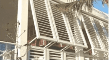 Building facade with white louvered panels.