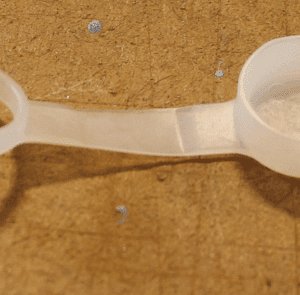 Plastic ring and cap on wooden surface.