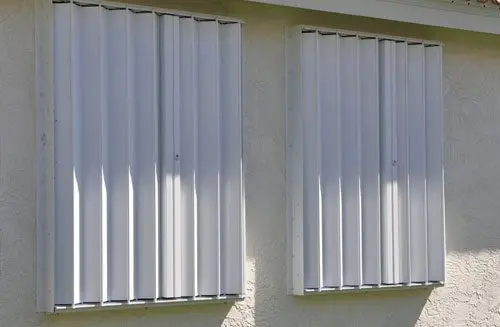 Metal hurricane shutters on two windows.