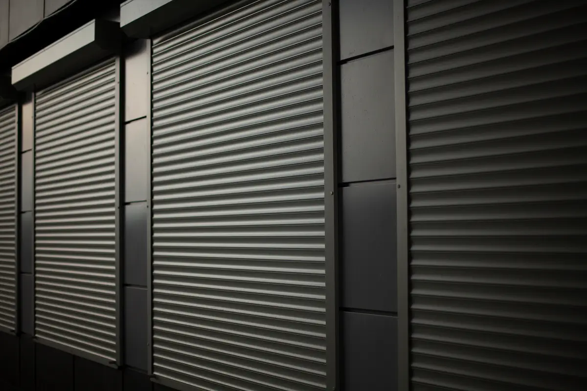 Closed gray metal security shutters on storefront